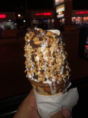 Large vanilla cone dipped in chocolate with peanuts