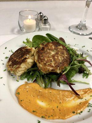 Jumbo Lump Crab Cakes, garnished with greens and a spicy aioli.