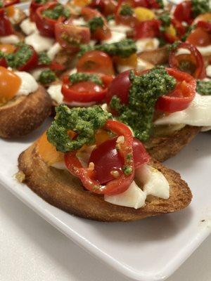 Bruschetta with roasted garlic crostini, fresh mozzarella, basil pesto, and pickled Fresno chiles