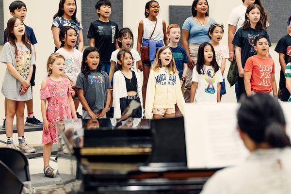 Merit School of Music choir students raise their voices.