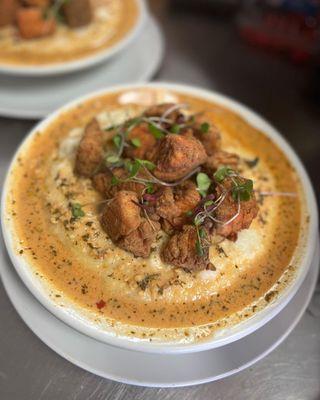 Fried Salmon Bites on a bed of Fluffy Grits with our Famous Cajun Cream Sauce