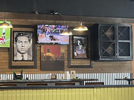 Bar area with old school mobster & prohibition art on the walls.