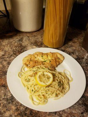 Chicken Francese, spaghetti with house salad somewhere out of frame.