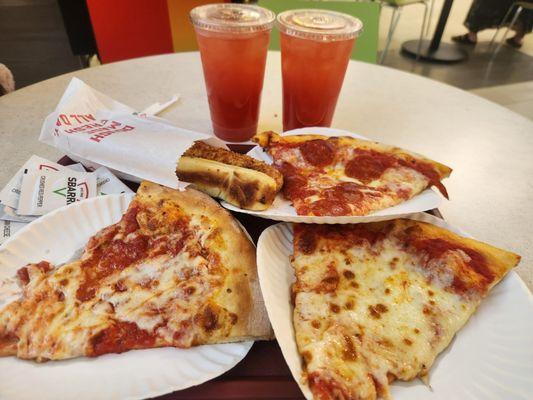 Strawberry lemonade with slices of pizza and bread sticks.