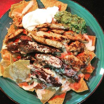 Blue Agave Nachos - Grilled Steak and Chicken over tortilla chips with cheese, sour cream, and guacamole. $8.