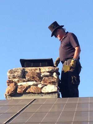 Vince inspects from the roof. His top hat adds to the mystique of the chimney sweep.