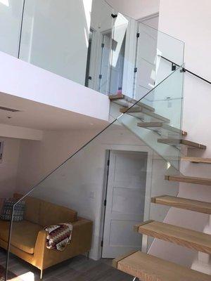 Custom glass railing with wood stairs.