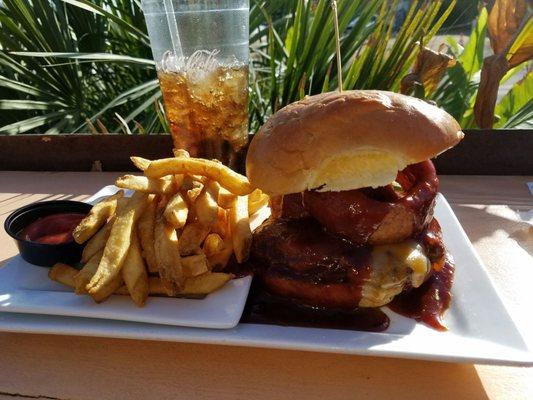 Burger topped with cheese, onion rings, and bbq sauce