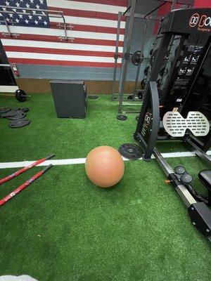 Free weights, ropes, bars and a ball left in the middle of the floor.