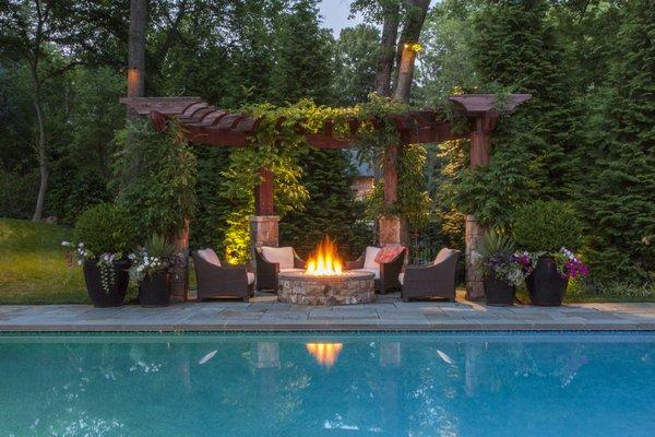 Who wouldn't want to sit by a firepit and under a pergola next to the pool?