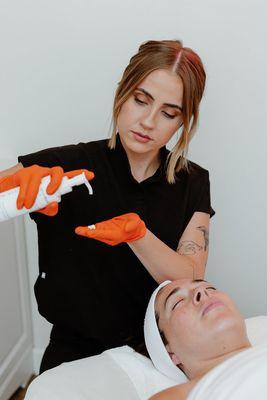 Shelby applying one of our most hydrating moisturizers as a finishing touch to her facial.