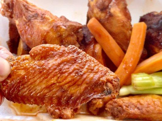 8 piece Buffalo wings with veggie sticks showing a flap well sauced and cooked just right