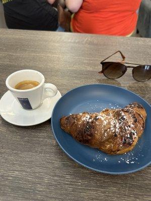 Small Italian lavazza espresso with a chocolate croissant.