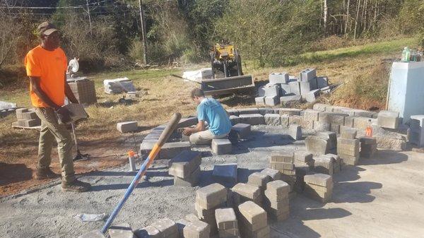 Building block bench, pavers, and fire pit area poolside.