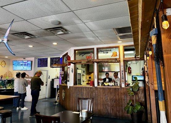 Inside order and pickup counter, chalkboard menu.