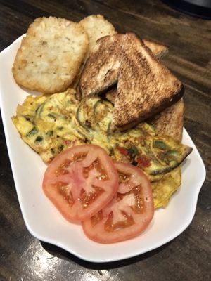 Vegetable omelette with hash browns and toast.