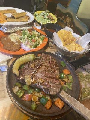 T bone steak with taquitos in the background.