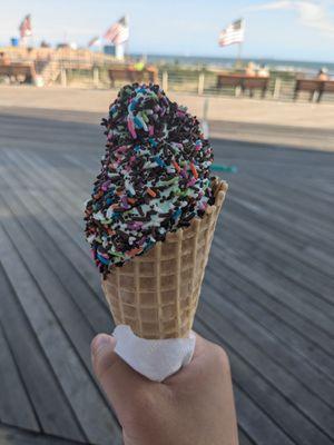 Pistachio soft serve with a mix in a waffle cone