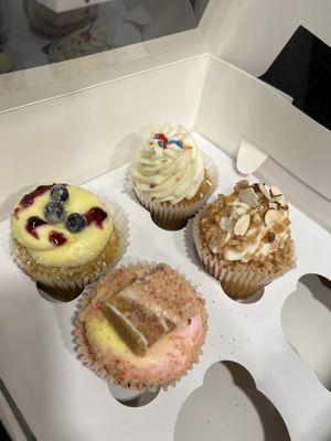 4 cupcakes (clockwise from top): vanilla, almond toffee, strawberry lemonade, lemon blueberry