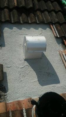 Next we install a modified cap sheet over vent and directly to the base sheet and seal with roof mastic and membrane.