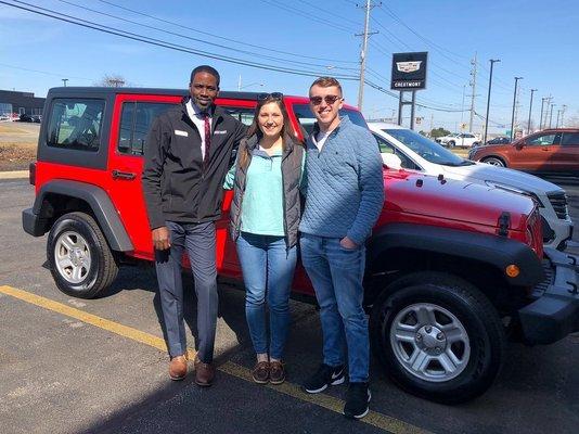 Damiean Tucker with his happy customers after selling them a Jeep.