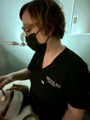 Susie painting a papaya masque on during a facial.