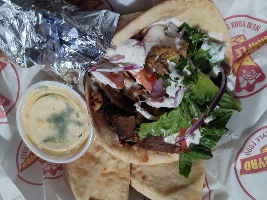 Gyro with lamb, chicken, and beef. With a side of Hummus and pita  bread.