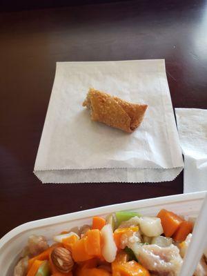 Egg roll served on a styrofoam plate and a to-go bag.