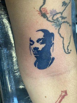 Small silhouette of Snoop Dogg tattoo done by Javier