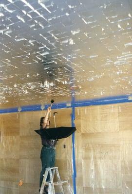 Applying gold leaf to an interior ceiling.