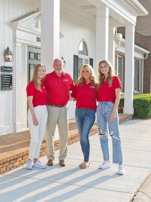 Dave with his wife & daughters in front of the agency.