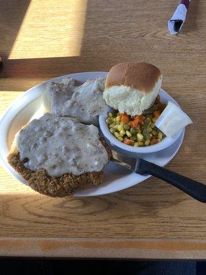 Chicken fried steak, mashed potatoes, mixed veggies, and roll.