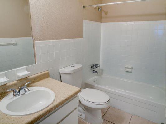 bathroom with beige walls and white shower, toilet and sink