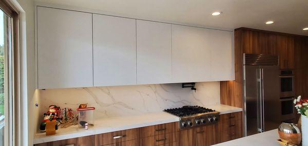 Quartz counters are used on backsplash for a clean look. Hood is hidden behind a panel