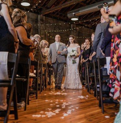 Bride and father walk down wedding aisle at Olio modern industrial event space north of Boston Massachusetts, New England