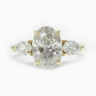 Custom- Three Stone, oval & pear cut lab diamond engagement ring in 14k yellow gold. With claw prongs.