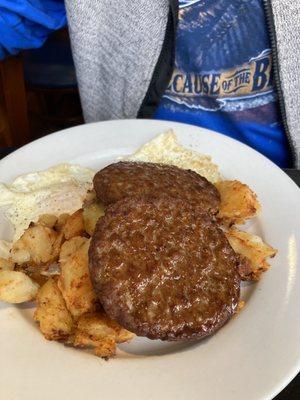 Sausage patty with eggs over easy and home fries