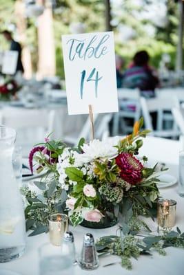 Example of the fantastic table arrangements by Hilary. Photo Credit: Laura Morsman Photography/ Table signs: JessicaRCrowell.com