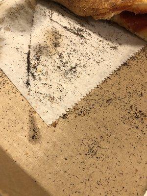 Looks like burnt dust. Prolly burnt corn meal or they just don't clean the oven. Pics don't lie. Every time I order its like this.