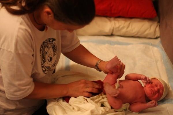 Midwife performing newborn exam