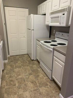 Kitchen 1BR unrennovated (in unit laundry behind closet doors)