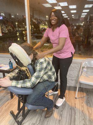 Chair Massage. Therapist is focused on shoulders and neck area which holds much tension