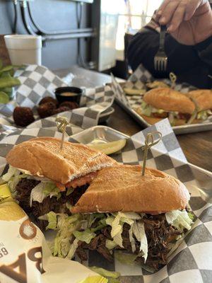 Roast Beef Po-boy with Boudin balls in the background.