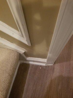 Uneven trimming and uneven wall at the bottom of the stairs with missing trimming