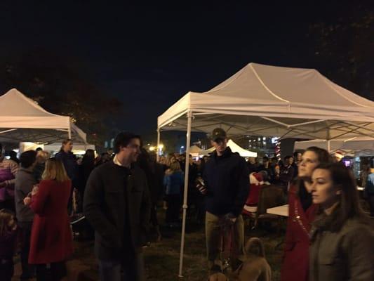 Crowds gathered and Santa in the background. Holiday festivities at the park.