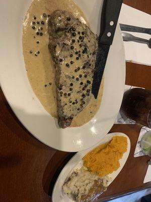 Steak au poivre with mashed potatoes and gravy and butternut squash