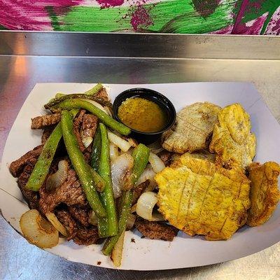 "Grilled steak strips with peppers & onions. Tostones with garlic aioli."