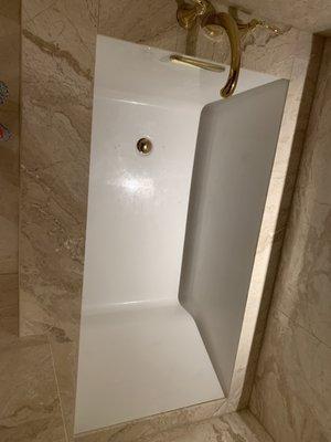 Bathtub drop in 66inch tub with Kohler faucet and drain. Surrounded by marble Trademark Flooring.