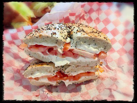 Inside look of everything bagel with cream cheese and tomato.