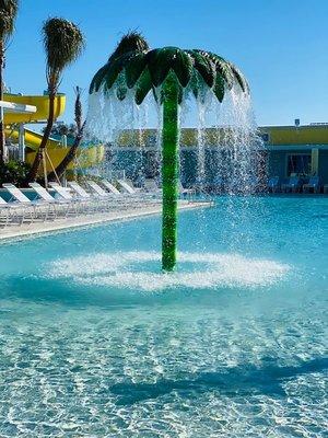 Relax at the large pool w waterslide and palm tree splash area